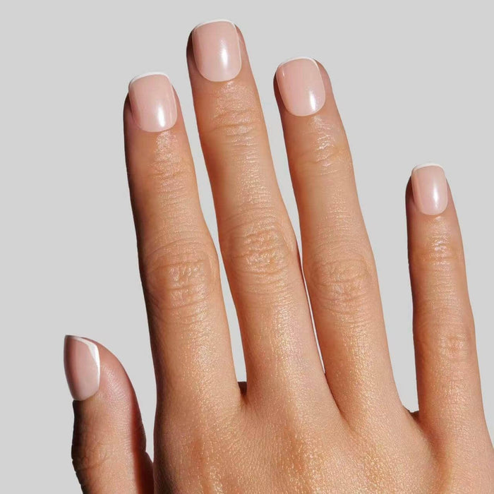 Model wearing Micro French Glaze nails showcasing pink and white ombre manicure design