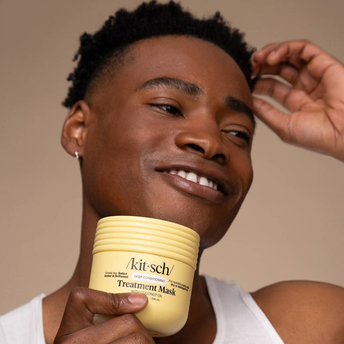 Man holding Kitsch coconut oil deep conditioning treatment mask against neutral background