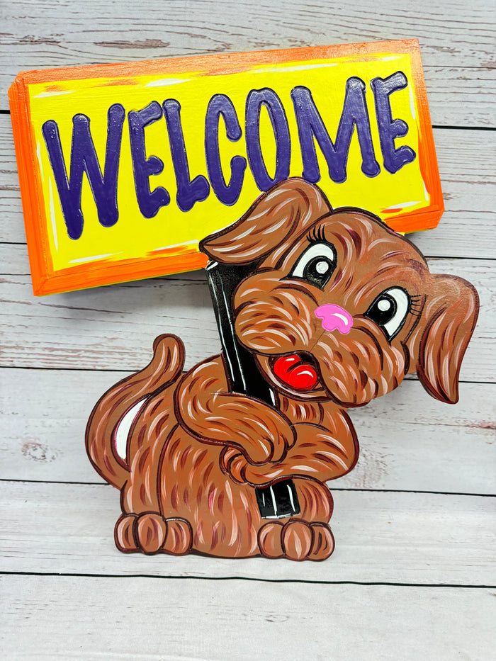A colorful outdoor decoration featuring a cartoon dog holding a 'Welcome' sign.