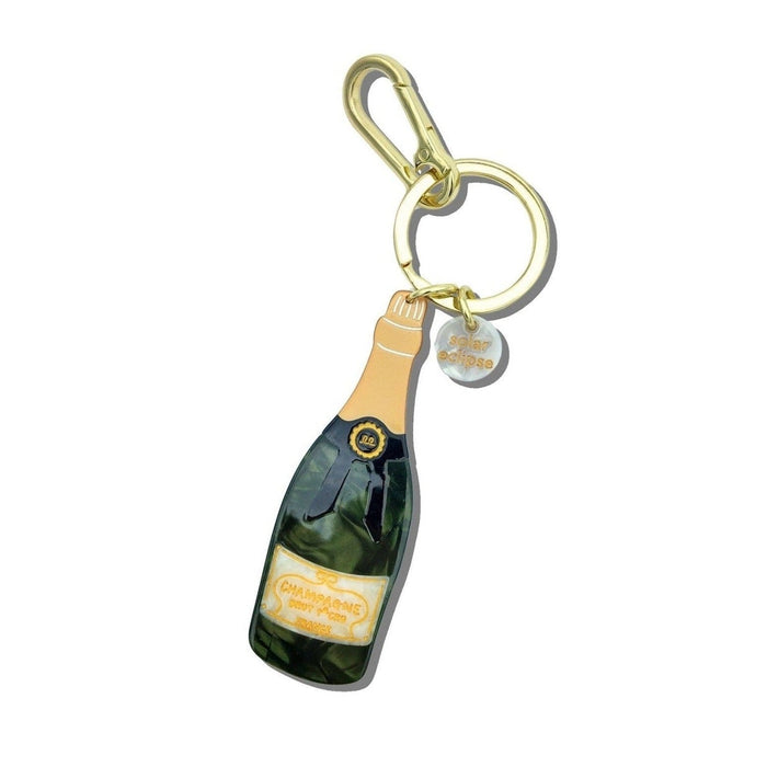 Hand-painted champagne bottle bag charm keychain with gold accents and charms on white background