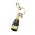 Hand-painted champagne bottle bag charm keychain with gold accents and charms on white background